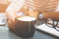 Close up people female sit hand holding cup coffee on desk table with book