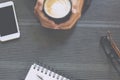 Close up people female sit hand holding cup coffee on desk table with book