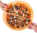 Close-up of people hands taking slices of pizza with cherry tomatoes, spinach, mozzarella, feta, kalamata olive and mushrooms
