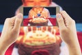 Close up of people take photo of a boy ready to blow