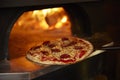 Close Up Of Pepperoni Pizza Being Baked In Wood Fired Oven