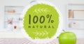 Close-up of 100 percent natural symbol sign by fresh granny smith apple on table Royalty Free Stock Photo