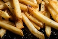 a close-up of perfectly cooked french fries, with a sprinkle of salt and pepper