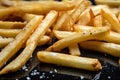 a close-up of perfectly cooked french fries, with a sprinkle of salt and pepper