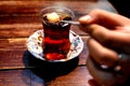 a close up of a person adding sugar to a cup of tea on a wooden table Royalty Free Stock Photo