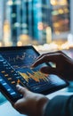 A close-up of a person analyzing data on a tablet against a backdrop of skyscrapers, showcasing modern financial technology Royalty Free Stock Photo