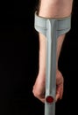 Close up of person hand with forearm crutches. Black isolated background vertical image. Back view