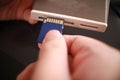 Close up of person hand inserting sd card memory into card reader, data transfer Royalty Free Stock Photo