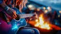 Close-up of a person playing guitar beside a warm glowing campfire at night Royalty Free Stock Photo