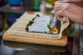 Close up of a person preparing japanese food. Close up of a person making sushi rolls. Close up of a person preparing sushi Royalty Free Stock Photo