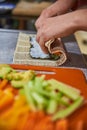 Close up of a person preparing japanese food. Close up of a person making sushi rolls. Close up of a person preparing sushi Royalty Free Stock Photo