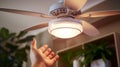 Close-up of a person\'s hand adjusting smart ceiling fans Royalty Free Stock Photo