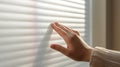 Close-up of a person\'s hand controlling smart blinds