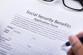 Person Filling Social Security Benefits Application Form