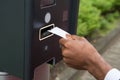 Close-up Of Person`s Hand Inserting Ticket Into Parking Meter Royalty Free Stock Photo