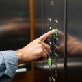 A close up of a person s hand pressing the UP button on an elevator control Royalty Free Stock Photo