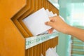 Close-up of person`s hand removing letter from mailbox Royalty Free Stock Photo