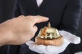 Person`s Hand Ringing Service Bell Hold By Waiter