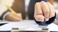 Close-up of a person`s hand stamping on an approved application form and approved contract form on paperwork at desk or a