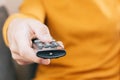 Close-up of a person`s hand with a tv remote control. Concept of technology, home, entertainment, series shows on streaming