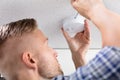 Person`s Hand Using Screwdriver To Install Smoke Detector Royalty Free Stock Photo