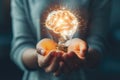 A close-up of a person\'s hands holding a glowing brain shaped light bulb, representing innovative ideas