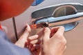 Close-up Of Person`s Young Man Locksmith Hand Opening Bronze Car Door With Lock picker