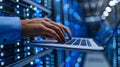 Close up of a person using a laptop in a data center with blue LED lights Royalty Free Stock Photo