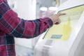 Close up person using touch screen panel in post office to recieve a package f