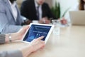 Close up of person video conferencing with colleagues on digital tablet, analyzing financial statistics displayed on the Royalty Free Stock Photo