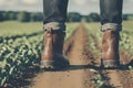 Close up of a person walking on the dirty field road, dirt road shoes , rough boots. Generative ai