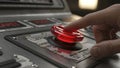 Closeup of a persons finger pressing a glowing red button on a control panel indicating action or activation Royalty Free Stock Photo