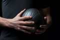 Close up of a persons hand gripping a round, textured ball