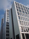 Close up perspective detail of a row of tall high rise modern apartment buildings with geometric white cladding and dark windows Royalty Free Stock Photo