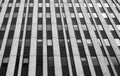 Close up perspective detail of tall high rise brutalist style office building with white vertical concrete lines and dark windows Royalty Free Stock Photo