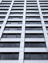 Close up perspective detail of tall high rose modern apartment building with white cladding and dark windows Royalty Free Stock Photo