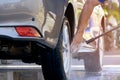 Man`s hand using high pressure water jet to washing his car outside of home at morning time Royalty Free Stock Photo