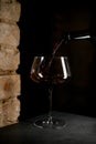 Close up perspective of wine glass filled with red wine with dark background Royalty Free Stock Photo