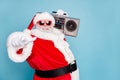 Close-up pf his he nice cool fat cheerful cheery glad bearded Santa clubber carrying tape player pointing at you invite