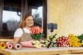 Close-up of the phone on which a woman is shooting a video for her blog, a florist girl is packing bouquets of tulips in