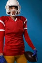 Close up photo of american woman football player in white helmet, sportswear and ball in her hand Royalty Free Stock Photo