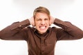 Close up photo of annoyed young man plugging ears with hands Royalty Free Stock Photo