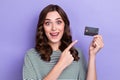 Close up photo of astonished cheerful lady bank client hand hold direct recommend plastic debit card isolated on purple