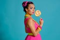 Lovely girl with a multi-colored braids hairstyle and bright make-up, posing in studio against a blue background Royalty Free Stock Photo