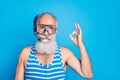 Close up photo of attractive man showing ok sign wearing snorkel gear striped bathing suit  over blue background Royalty Free Stock Photo