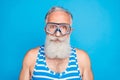 Close up photo of attractive sailor in swimming glasses wearing striped costume isolated over blue background