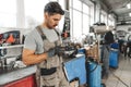 Close up of automechanic using cellphone at workplace in car service