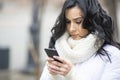 Close up photo of a b eautiful brunette with a smartphone on the street of a European city.