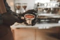 Close up photo barista hands holding a portafilter with ground coffee. Making coffee in a coffee shop. Background. Copyspace