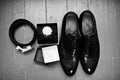 Close-up photo of black groom`s brogue shoes, watch, wedding rin